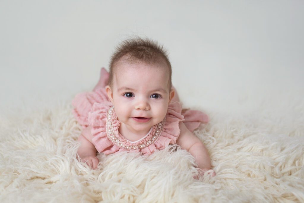 baby girl in pink lifting on arms at Just Peachy Photography Baby Portrait Studio in Palatine IL