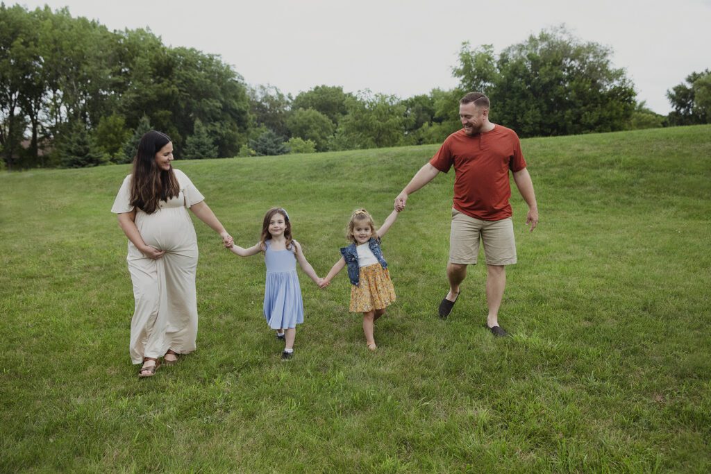 family with expecting mother walking together and having fun| Photographer Just Peachy Photography Palatine, IL